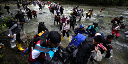 Migrants, mostly Venezuelans, cross a river during their journey through the Darien Gap from Colombia into Panama, on Oct. 15, 2022.